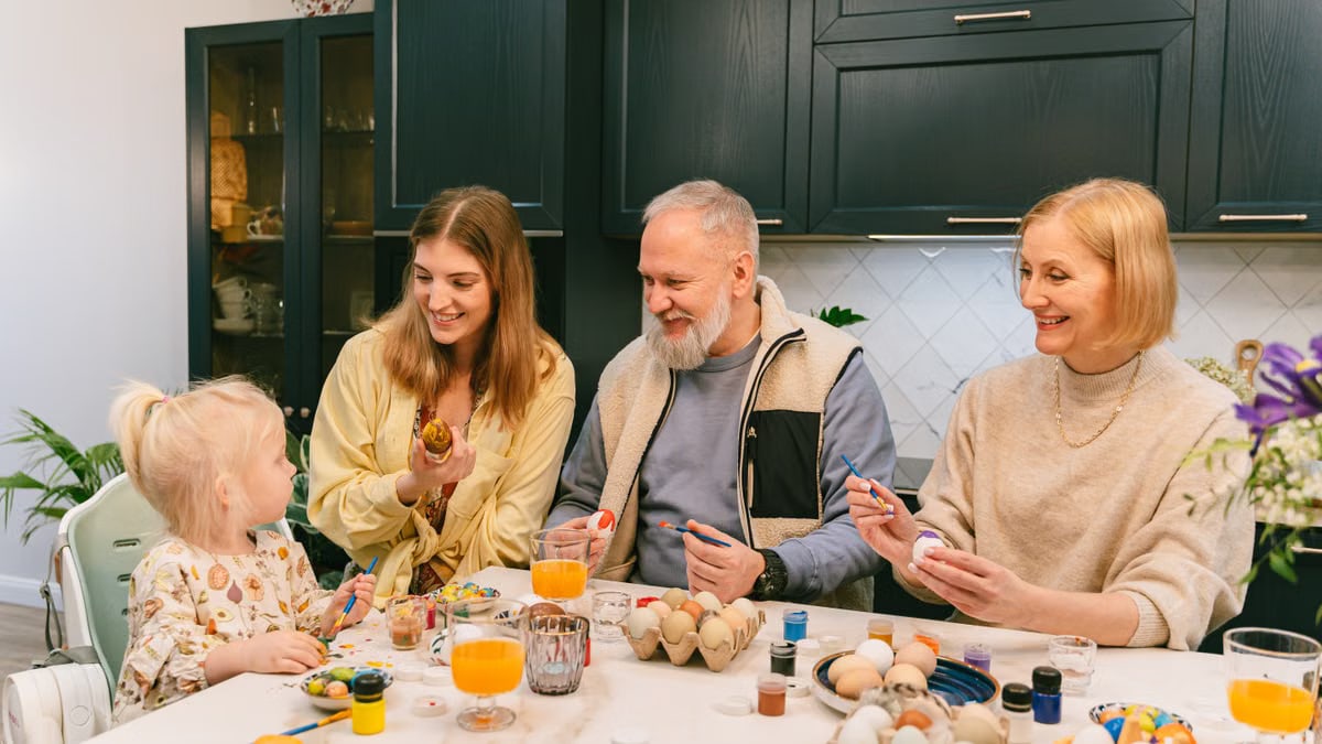 A joyful family bonding over painting Easter eggs in the kitchen, enjoying quality time.